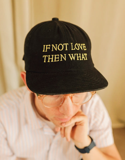 Black cotton hat featuring yellow embroidered text that reads "IF NOT LOVE THEN WHAT"